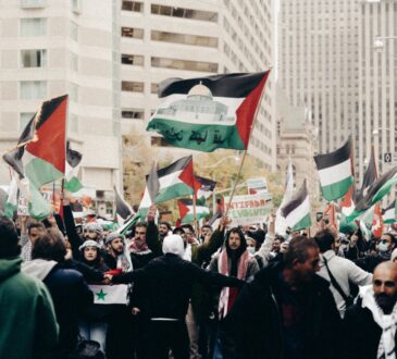 people holding palestinian flags protesting on the street