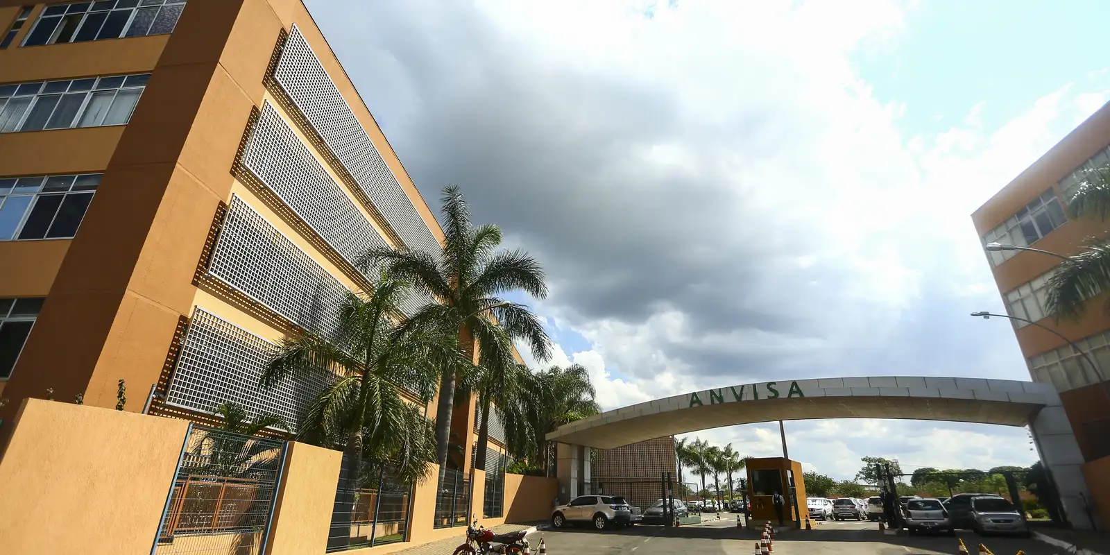 Fachada da sede da Anvisa, em Brasília, com portaria e palmeiras