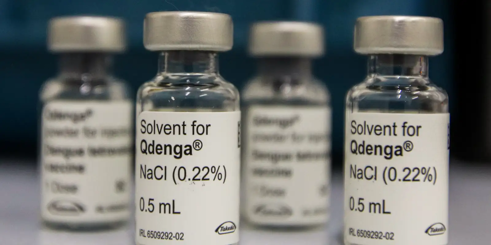 Frascos da vacina contra a dengue Qdenga e do diluente sobre uma mesa