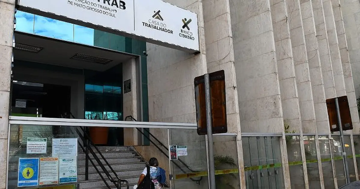 Fachada da sede da Funtrab, com placas da fundação e pessoa na escada de acesso