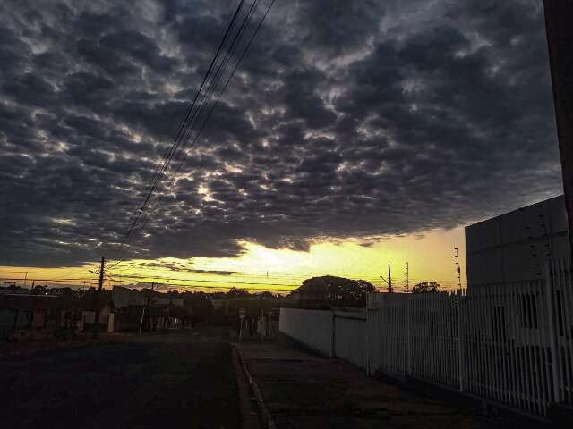 Céu encoberto por nuvens carregadas com faixa de luz do amanhecer em Campo Grande