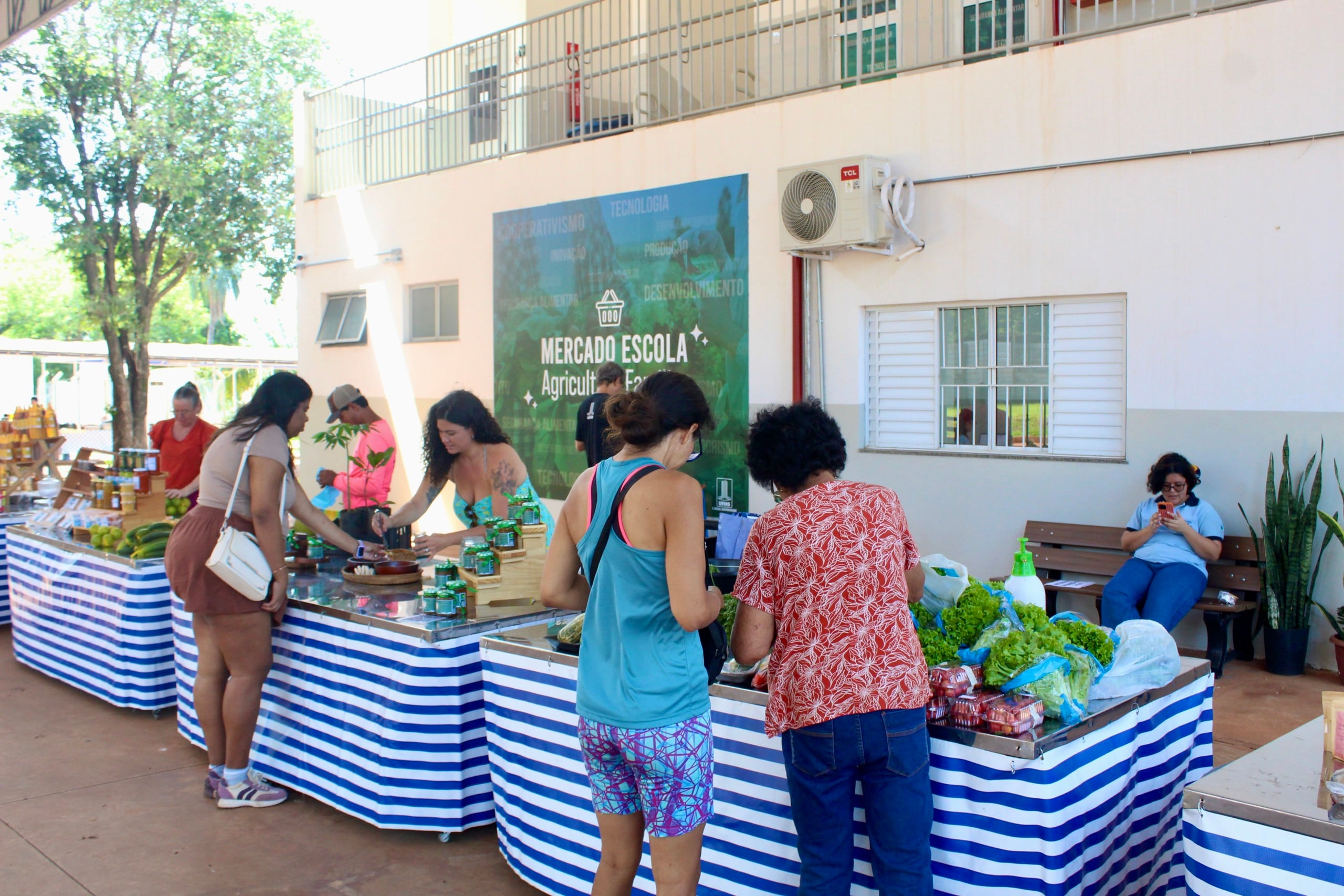 Barracas e público em área aberta de comercialização do Mercado Escola na Cidade Universitária
