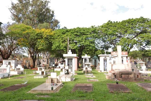 Túmulos e jazigos entre árvores em cemitério de Campo Grande