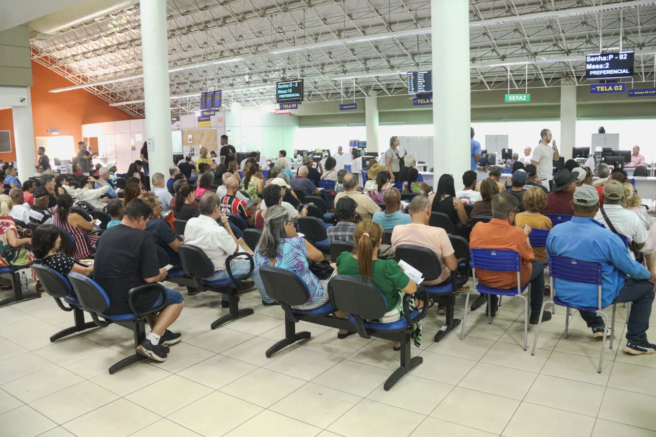 Saguão da Central de Atendimento ao Cidadão de Campo Grande com contribuintes sentados aguardando senha