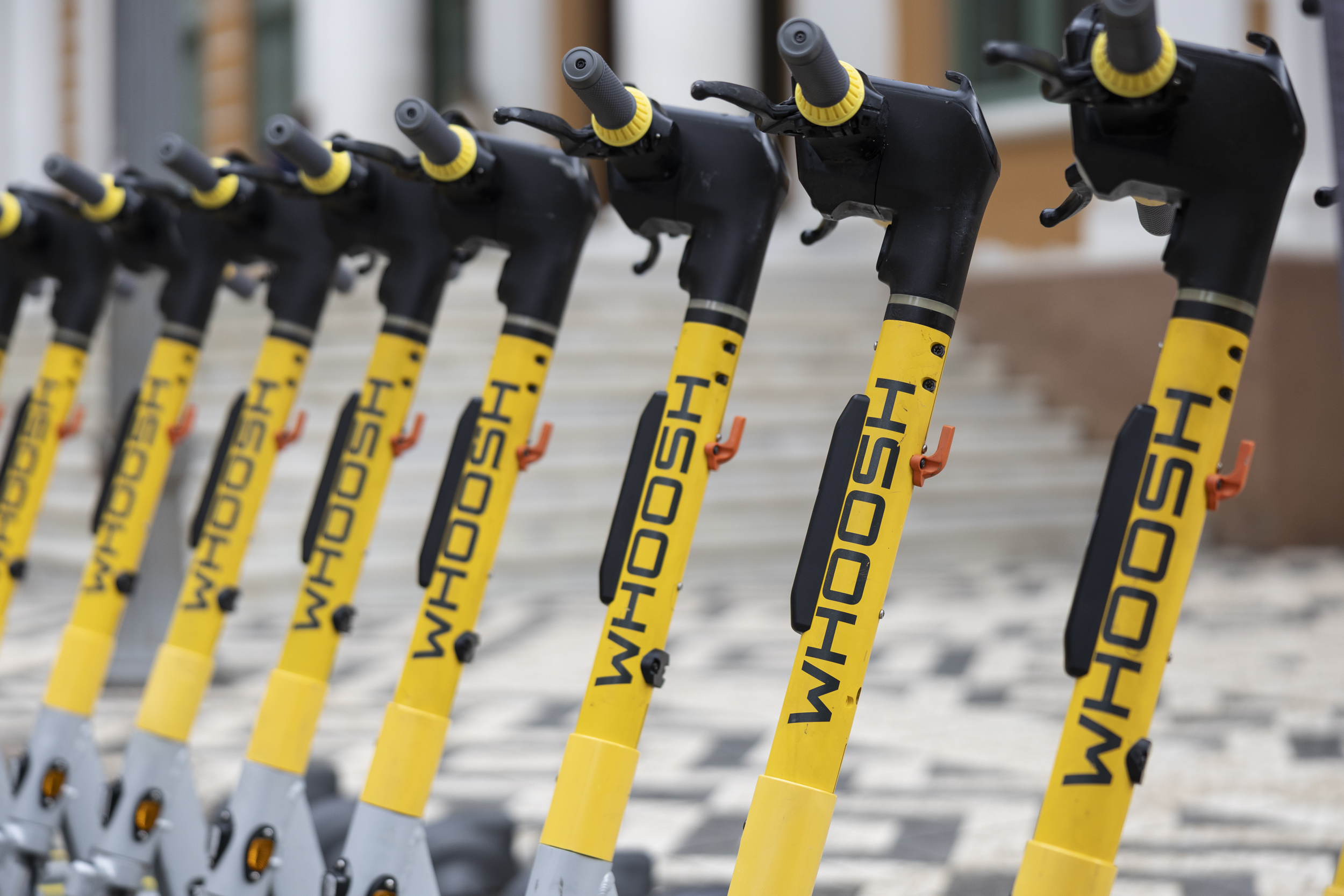 Patinetes elétricas Whoosh estacionadas em via urbana